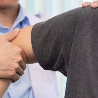Physician examining man's shoulder