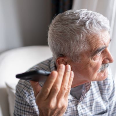 older man with phone by ear