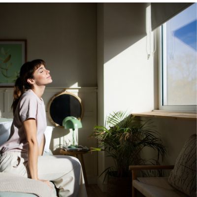 Woman waking up with a sunny window