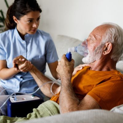 Man with oxygen and caretaker