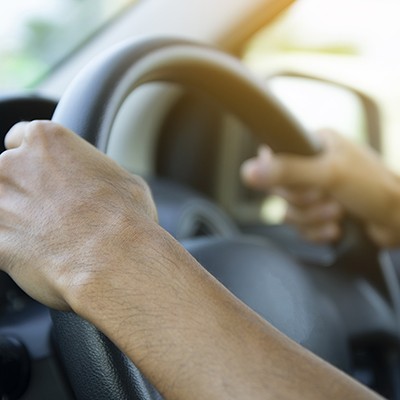 Hands driving on wheel image