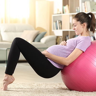 Pregnant woman leaning on an exercise ball