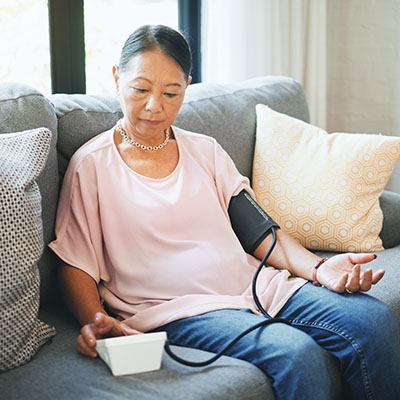 woman taking her blood pressure at home