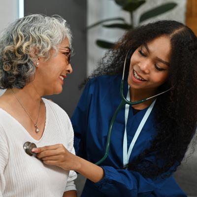 Nurse using a stethoscope on a patient