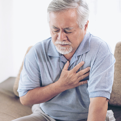 older man holding chest