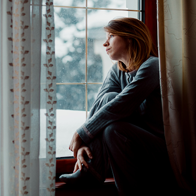 Woman staring out the window sadly