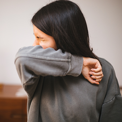 Woman coughing into her elbow