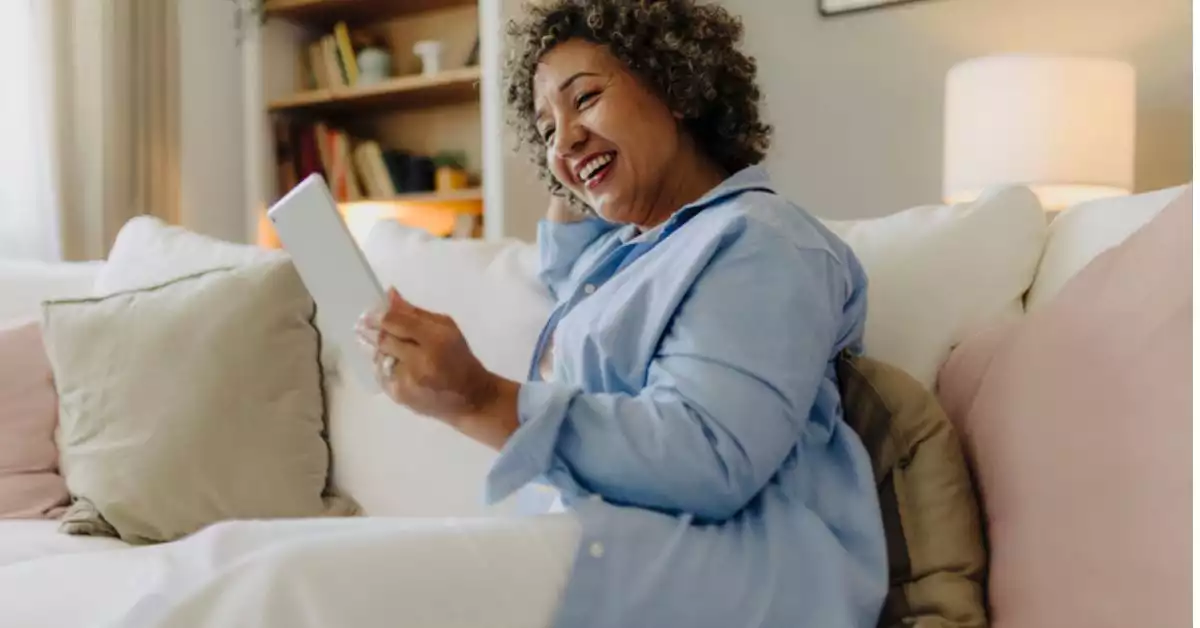 Woman on couch reading tablet