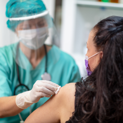 Clinician give patient a flu shot in arm