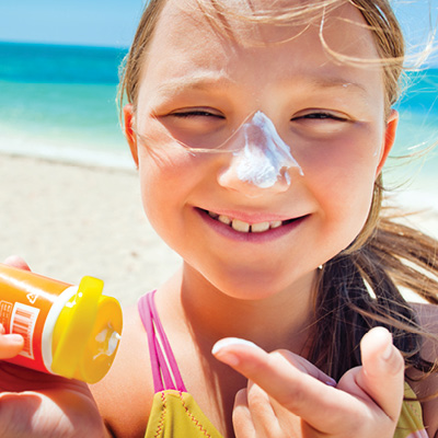 Child with Sunscreen on their nose at the beach