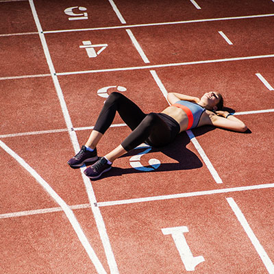 recovery Woman laying on running track