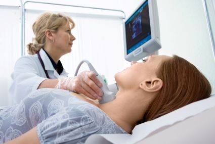 Nurse scanning throat for cancer