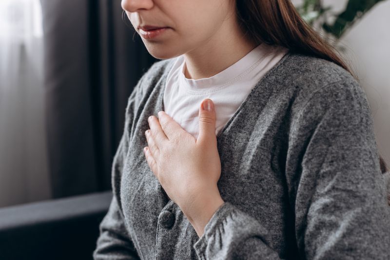 Young woman holding hand over her heart