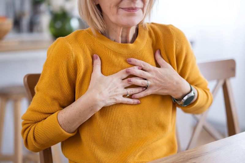 Older woman holding chest in pain