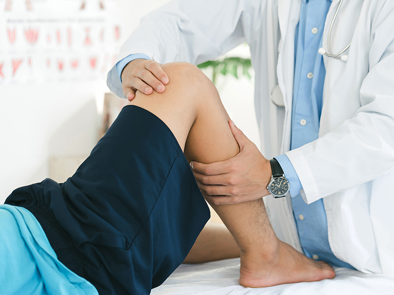 Sports Medicine doctor looking over patients knee and leg
