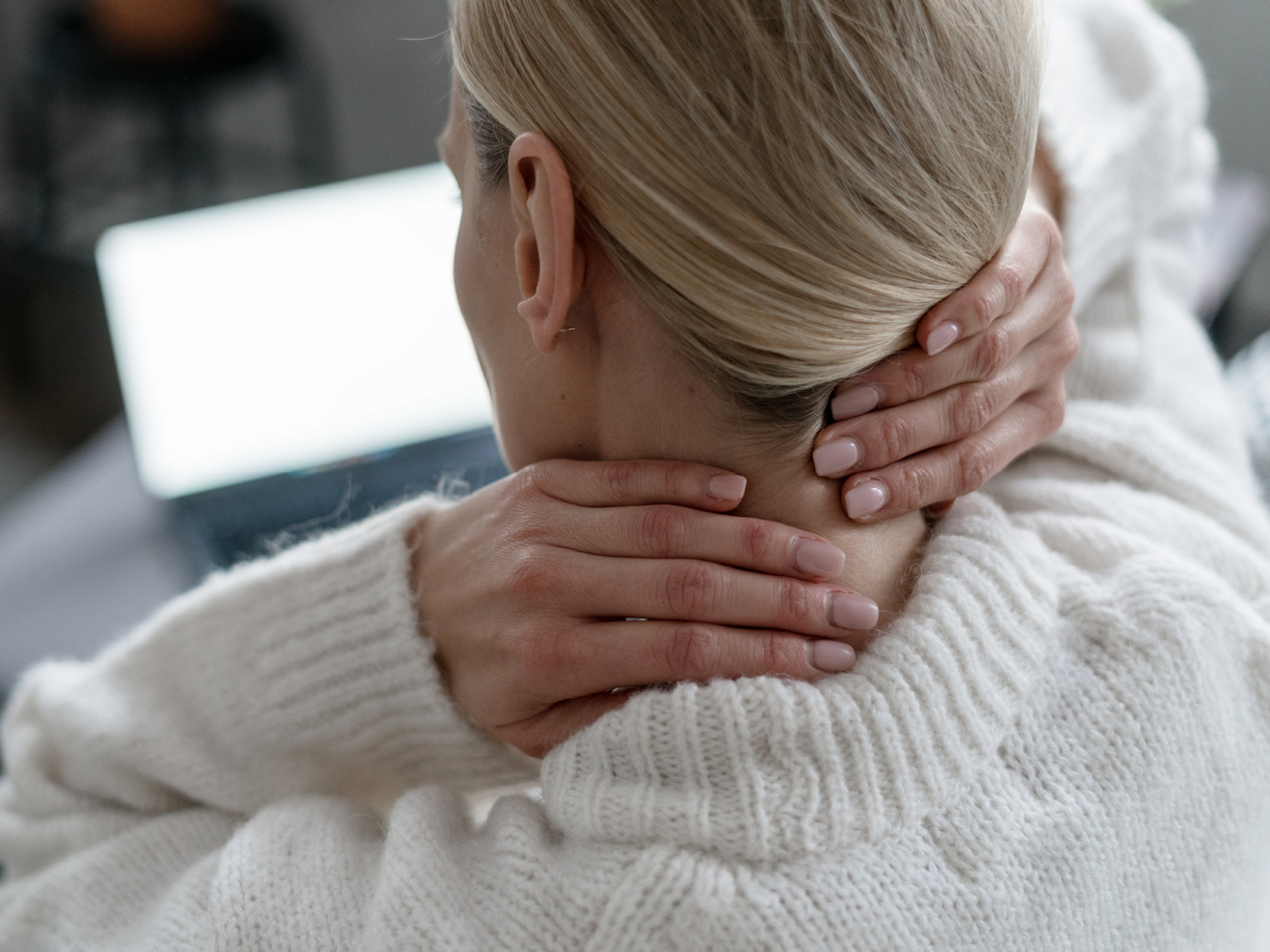 Woman rubbing the back of neck