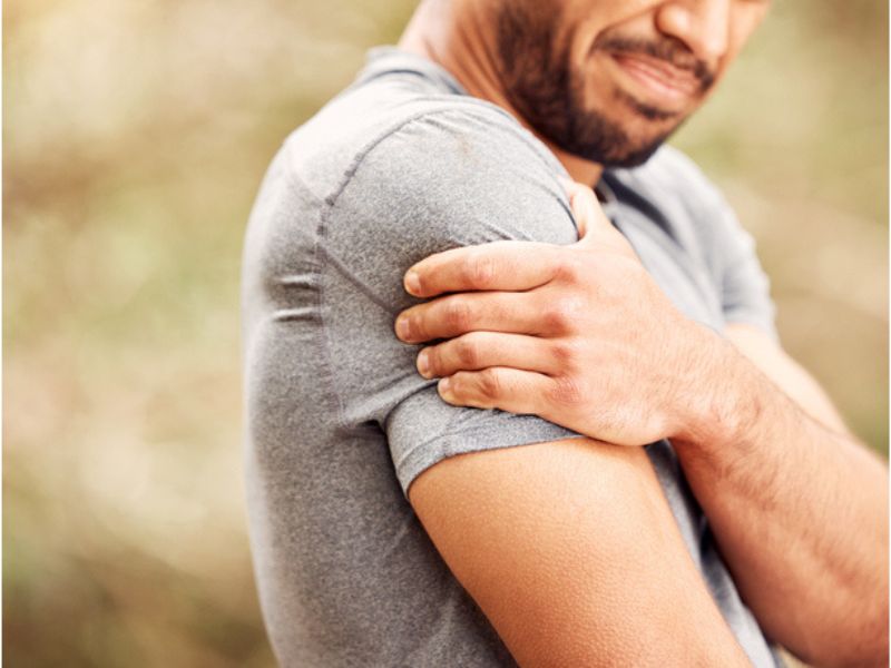 Man holding onto his shoulder