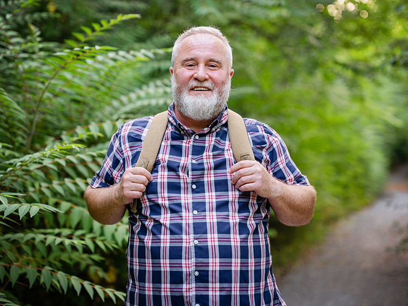 man hiking and smiling