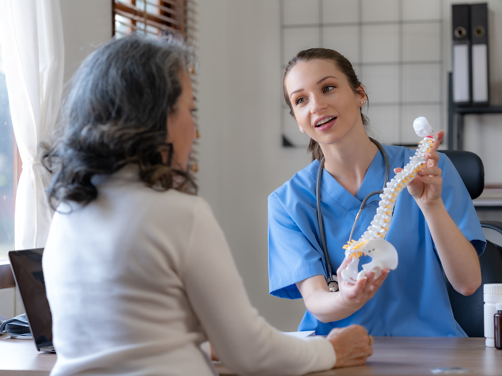 Woman and provider reviewing bones and spine