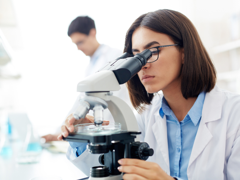 researcher looking at microscope