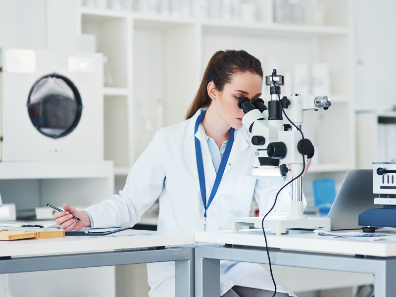 medical researcher looking in microscope